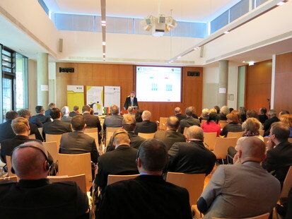 Blick in den Konferenzraum auf die Teilnehmer von hinten.