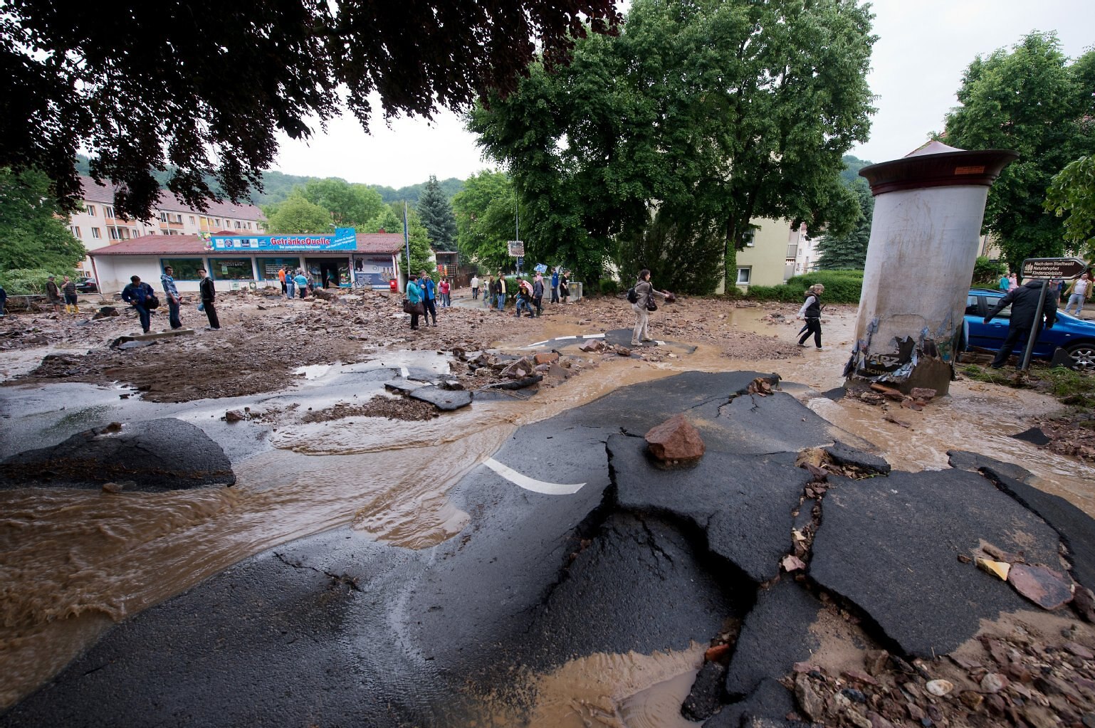 ein Teil eines durch Überschwemmung zerstörten Parkes in Meißen Triebischtal im Mai 2014, im Hintergrund fassungslos schauende Menschen