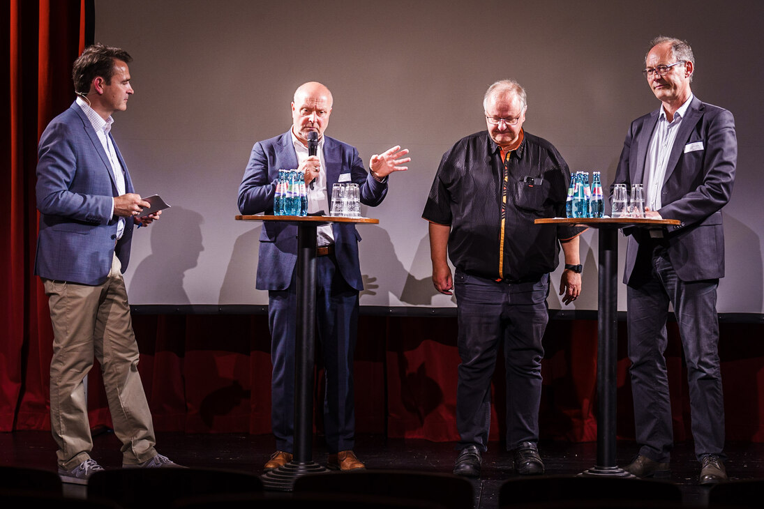 Die abschließende Podiumsdiskussion, von links nach rechts stehend zu sehen: Moderator Ingo Seeligmüller, Uwe Weigelt, Dr. Andreas Berkner, Hans Jürgen Wolf